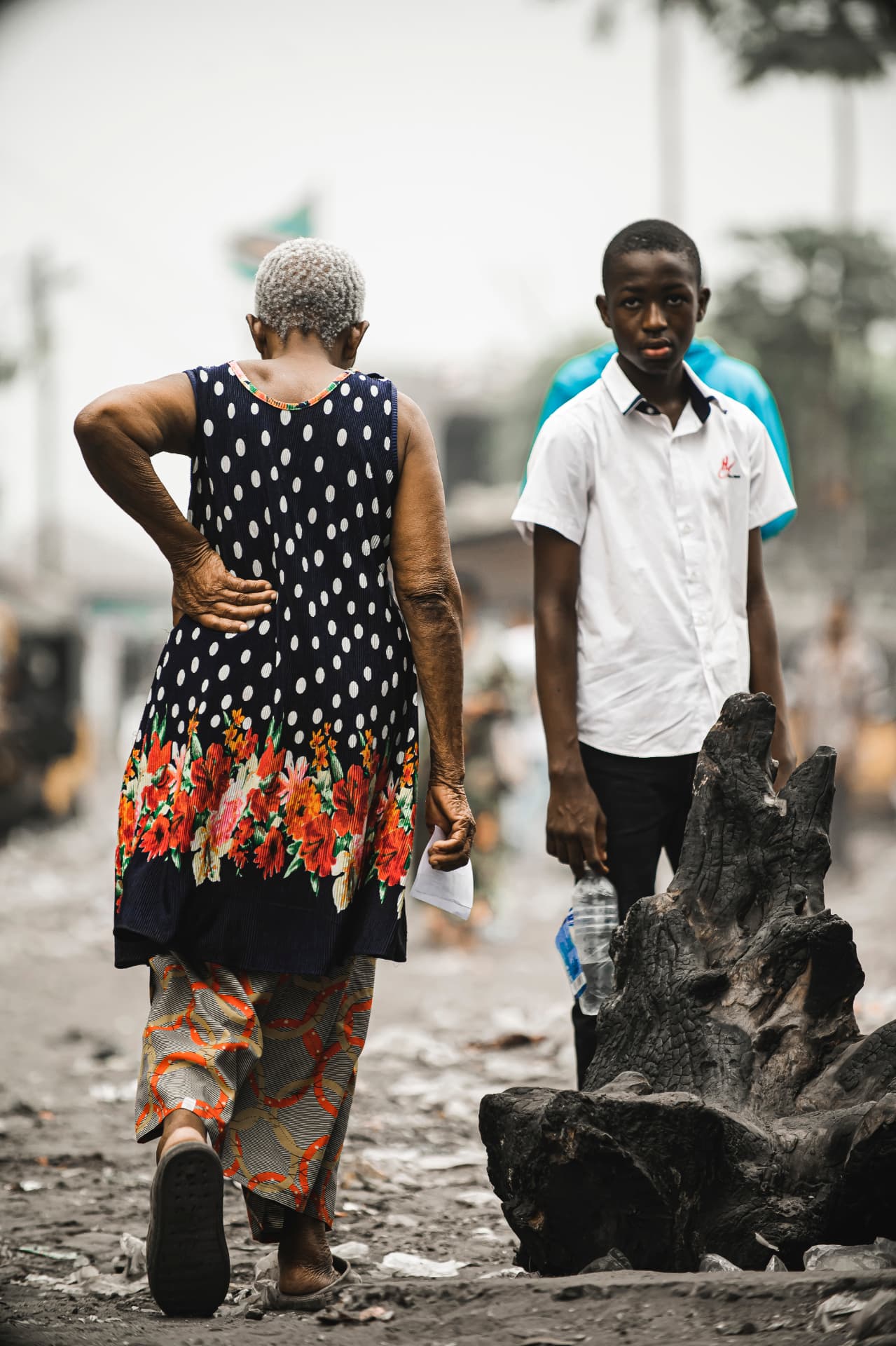 Une femme âgée et un jeune garçon se croisent dans une rue de Kinshasa