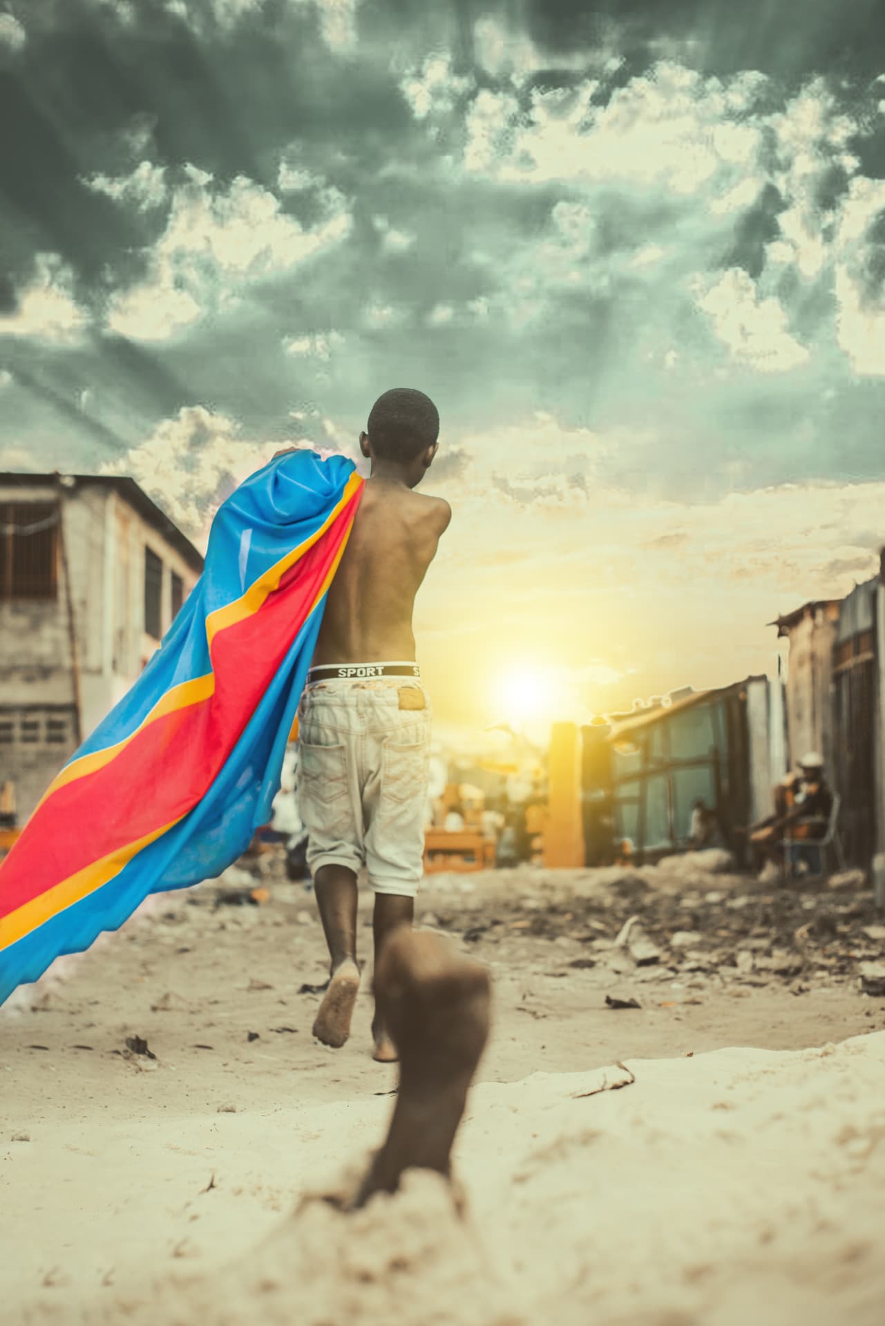 Un enfant marche avec le drapeau congolais sur les épaules