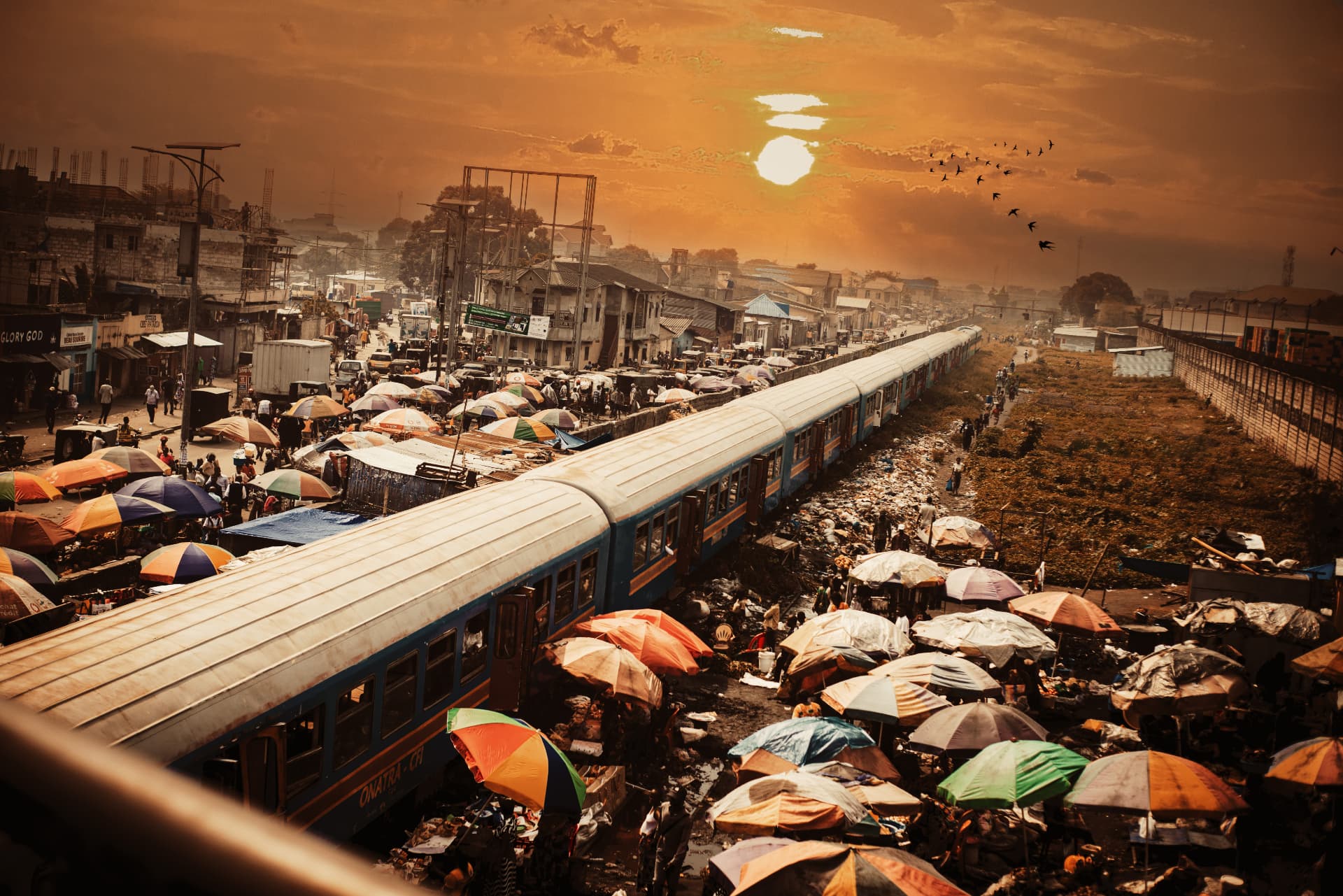 Un train traverse un marché de Kinshasa au coucher du soleil
