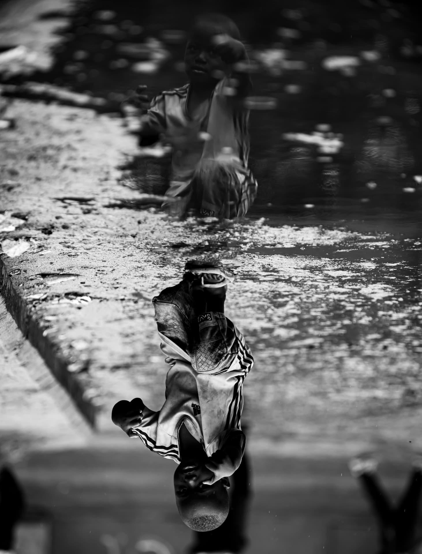 Reflet inversé d un enfant dans une flaque d eau